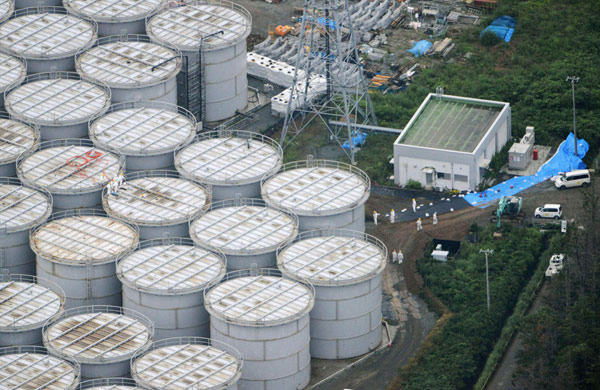 Workers wearing protective suits and masks inspect contaminated water storage tanks at Tokyo Electric Power Co's tsunami-crippled Fukushima Daiichi nuclear power plant in Fukushima, Japan, on Tuesday. Kyodo via Reuters Japan may raise nuclear leak to 'serious'